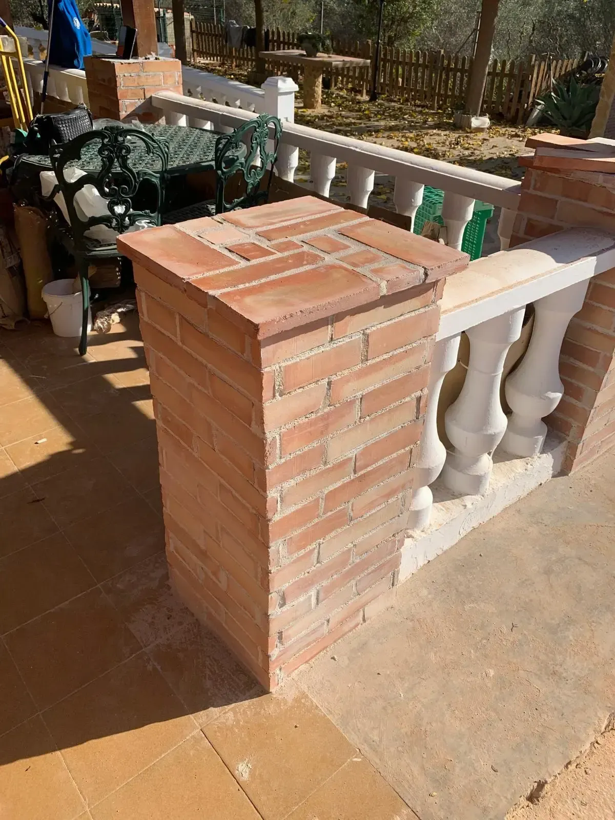 Pilar de ladrillo junto a una balaustrada
